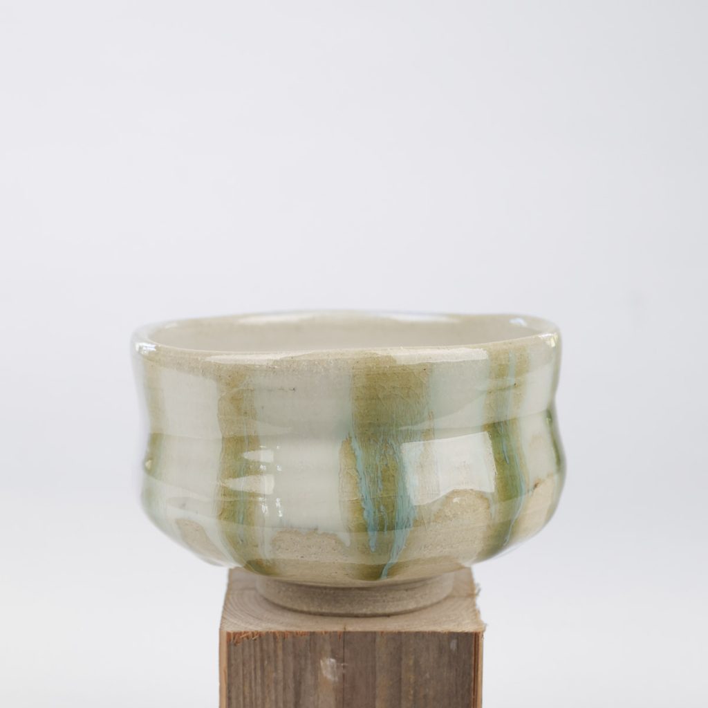 Japansk handgjord matchaskål i ljus lera och glasyr i vitt, olivgrönt och turkost, Hagi ware